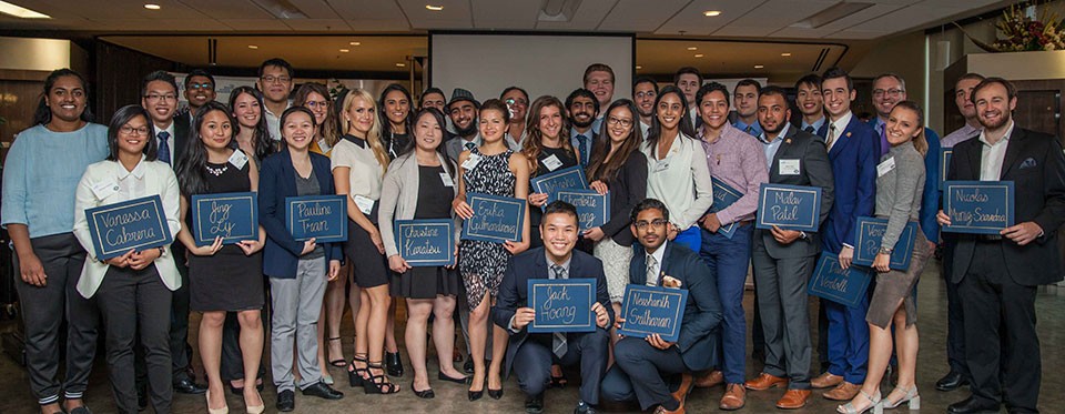 Team of students and faculty members in business attire at an awards ceremony 2016
